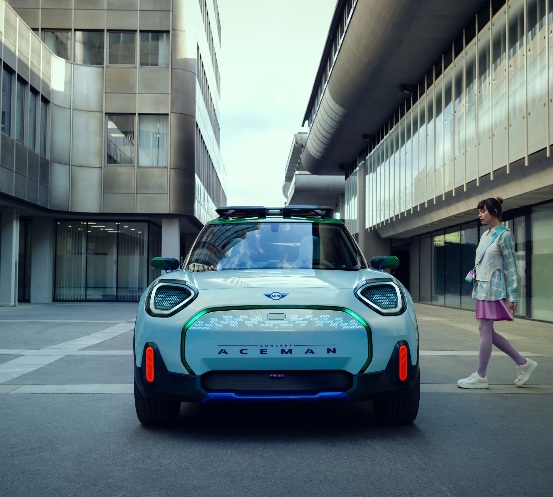 MINI Concept Aceman Imagem frontal do novo MINI Concept Aceman, enquanto mulher se encaminha para entrar nele.